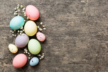 Happy Easter composition. Easter eggs on colored table with gypsophila. Natural dyed colorful eggs background top view with copy space
