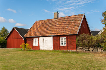 Fototapeta na wymiar Old red wooden house in vintage Scandinavian style. Traditional ancient Sweden house in the village. 