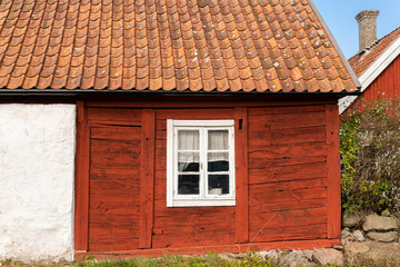 Fototapeta na wymiar Old red wooden house in vintage Scandinavian style. Traditional ancient Sweden house in the village. 