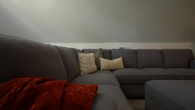 Grey couch in the extra living room loft with pillows and a blanket, hang out area, lounge space