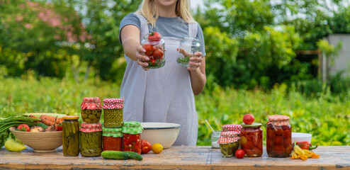A woman preserves vegetables in jars. Selective focus.