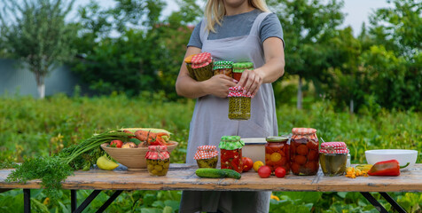A woman preserves vegetables in jars. Selective focus.