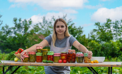 A woman preserves vegetables in jars. Selective focus.