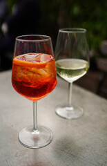 Aperol drink on white table with blue background. Sunshine and palm leaf shadow drink modern still life. Summer, party, tropical and freshness concept