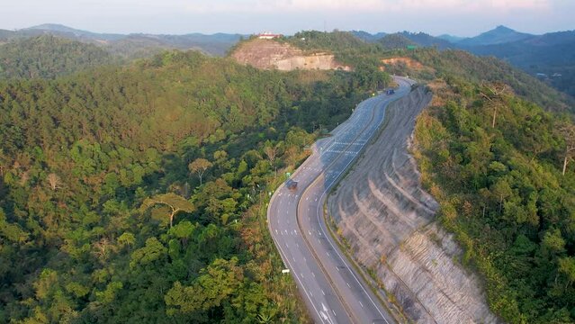 Aerial view drone beautiful of road curve with forest wood tree mountain nature and car driving along the road.