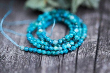 The photo with blue chrysocolla stones is made on the background of a wooden board and dried hydrangea.