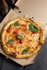 Delicious pizza with prosciutto, herbs and cheese. Food delivery
