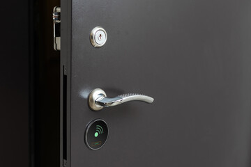 To open the door. Modern white door with chrome metal handle. Elements of interior closeup