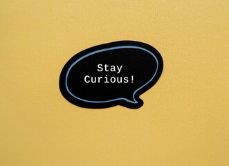 Speech sticker on beige background with text STAY CURIOUS - refers to desire to learn or know about...