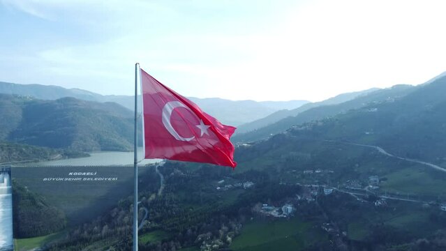 Turkish flag on top of the mountain. Turkish flag at the top with beautiful view. Turkish National holidays. 23 Nisan, 19 Mayis, 30 Agustos, 29 Ekim concept. Drone view. Aerial cinematic shot.