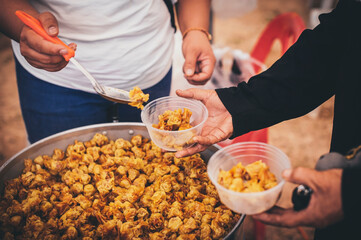 Volunteers distribute simple meals to the poor at the free food kitchen.