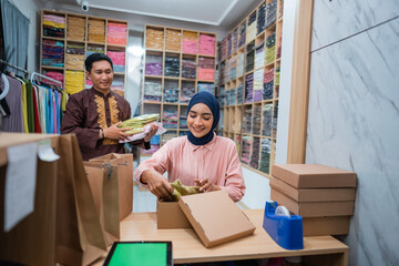 Muslim female and male preparing delivery parcel at the shop. Ecommerce dropshipping shipment service for fashion store