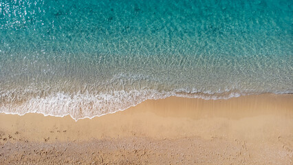 Aerial view of beautiful sandy beach and soft turquoise ocean wave. Tropical sea in summer season...