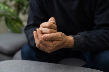 Worried religious senior man praying to god with his hands raised and touching as he looks beseechingly towards heaven for help and inspiration.