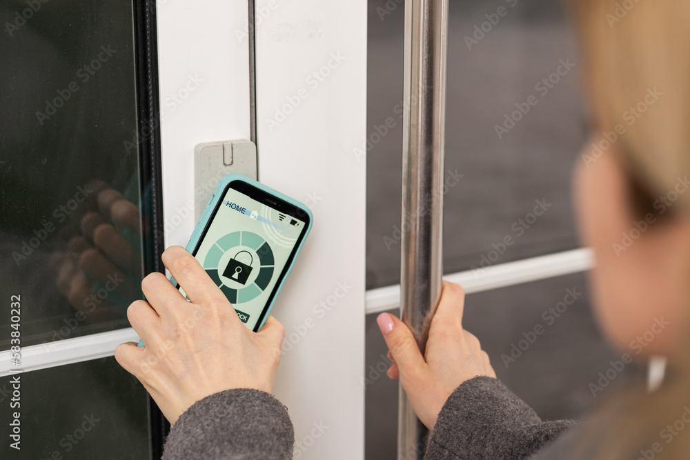 Poster young stylish woman getting access to the building by attaching smartphone to intercom. concept of m