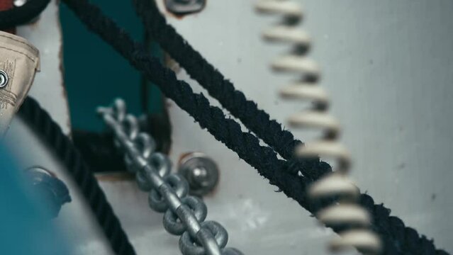 Close-up of lifting anchor into the fairlead on the catamaran. Long metal chain. Ropes. Sailing. Sea trip. 