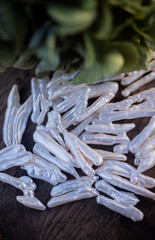 Natural freshwater pearls of various shapes and colors are photographed on a wooden board 