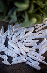 Natural freshwater pearls of various shapes and colors are photographed on a wooden board 