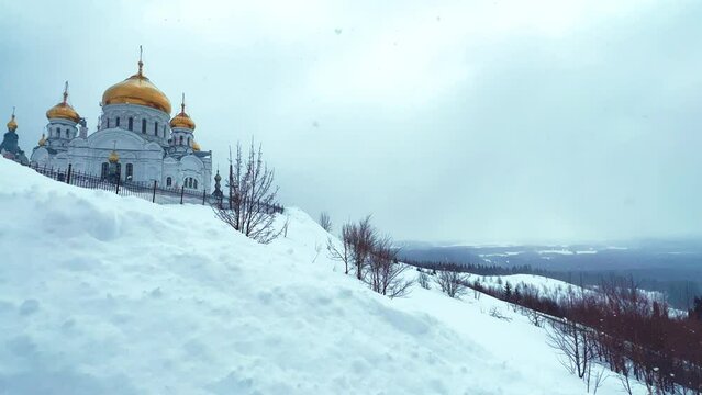 Belogorsky St. Nicholas Orthodox Missionary Monastery. Russia, Perm Krai, Belaya Gora. The temple on the hill in winter. Monastery on the background of snow. 4K