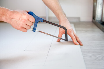 a man saws off drywall for an interior wall with a saw. Diy - obrazy, fototapety, plakaty