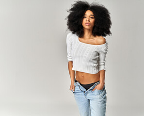 Attractive african american girl with an afro hairstyle isolated on gray background