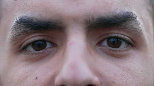 One young Middle Eastern man macro close up eyes looking at camera. Male person face detail