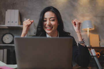 A happy and joyful Asian business woman feeling triumph, winner and achievement. A Female...