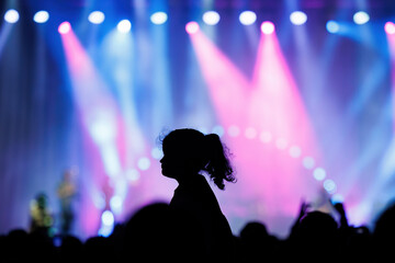 Silhouette of an unrecognizable child on father's shoulder in a concert