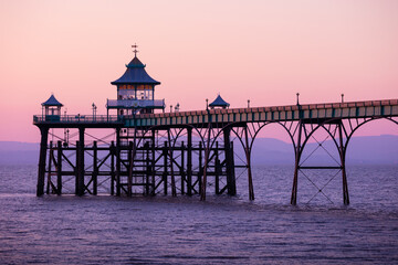 View of old Victorian ocean pier in Clevedon, Somerset, England at sunset