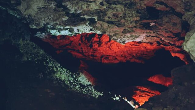 Excursion to the dark ice cave in winter. Underground large stone cave. Tourism in Russia, the concept of speleology. Kungur ice cave. Perm Region. Matte illuminated walls in an Ice Cave. 4k