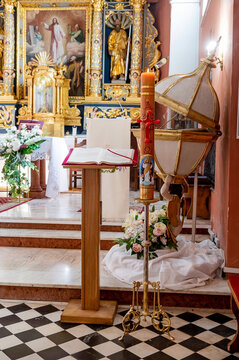  Baptismal font and yellow Paschal next to gospel in a Church in Cieksyn