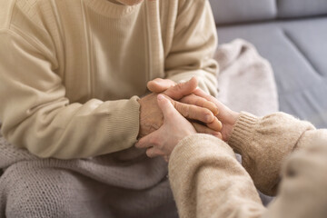 Young woman holding senior man hands, closeup