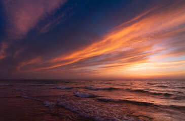 Sunset over the sea shore, sandy beach, colorful sky