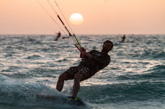 Bat Yam, Israel - May 18, 2020: People ride a Kiteboarding during the sunset. Mediterranean sea