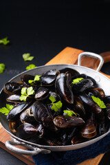 Food concept Fresh Mussels in the pan on black background with copy space