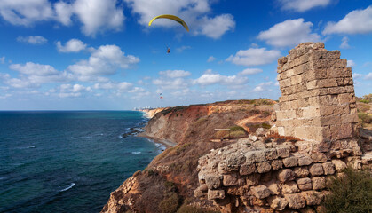 The Crusader Fortress in Herzliya panorama. A man is flying in the air on a paraglider