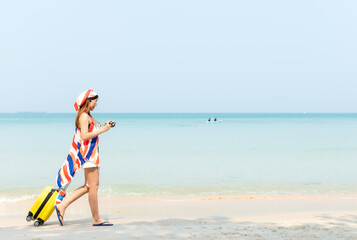 Summer vacations. Lifestyle woman talk a photo and relax chill on beach background.  Asia happy young people with yellow suitcase  fashion summer.  Travel summer vacations, copy space