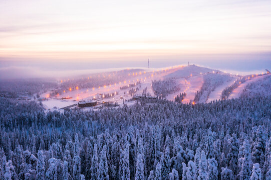 Mist at sunset over Ruka ski resort and snowy woods in winter, aerial view, Kuusamo, Northern Ostrobothnia, Lapland