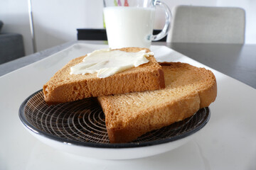 Zwieback auf einem Teller und ein Glas Milch