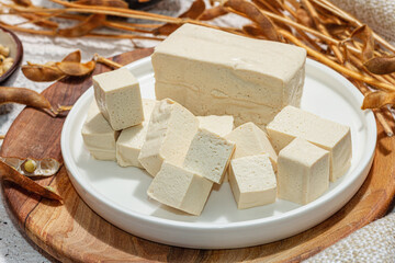 Fresh Tofu cheese with soybeans. Cube pieces, healthy ingredient for vegan lifestyle, modern stand