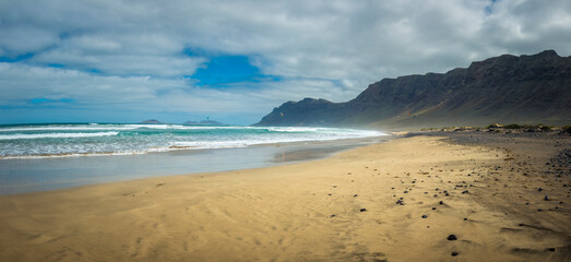 View on Famara beach on the Canary Island of Lanzarote, with some windsurfing in the far distance