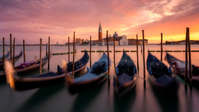 Venetian gondolas at sunset with the church of San Giorgio Maggiore in the background, Venice, UNESCO World Heritage Site, Veneto