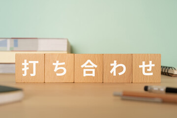 打ち合わせと書かれたブロックが置かれたデスク