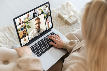 Excited smiling woman have laptop video chat. Young female at home in happy Christmas mood.