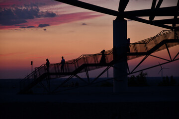 Silhouettes of people of the viewing platform Tetraeder Bottrop in Bottrop, Germany at sunset