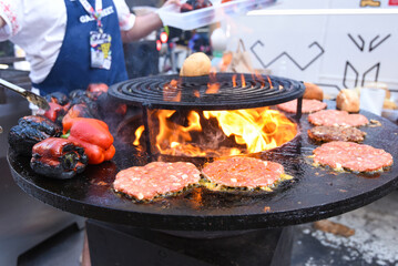 variety of food happens at the waterfall, picnic. Round grill bowl, round roaster with a fire in the center.