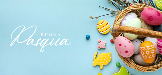 Buona Pasqua. Lettering in lingua italiana su sfondo azzurro. Immagine di un cesto pieno di uova...
