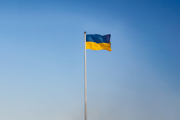 The flag of Ukraine blue and yellow on a sunny day in a blue sky.  