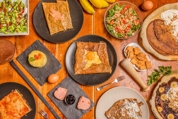 Set of dishes with French food recipes with crepes, salads and fresh fruits