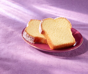 Sandkuchen in Scheiben auf lila Serviette und pinkem Teller